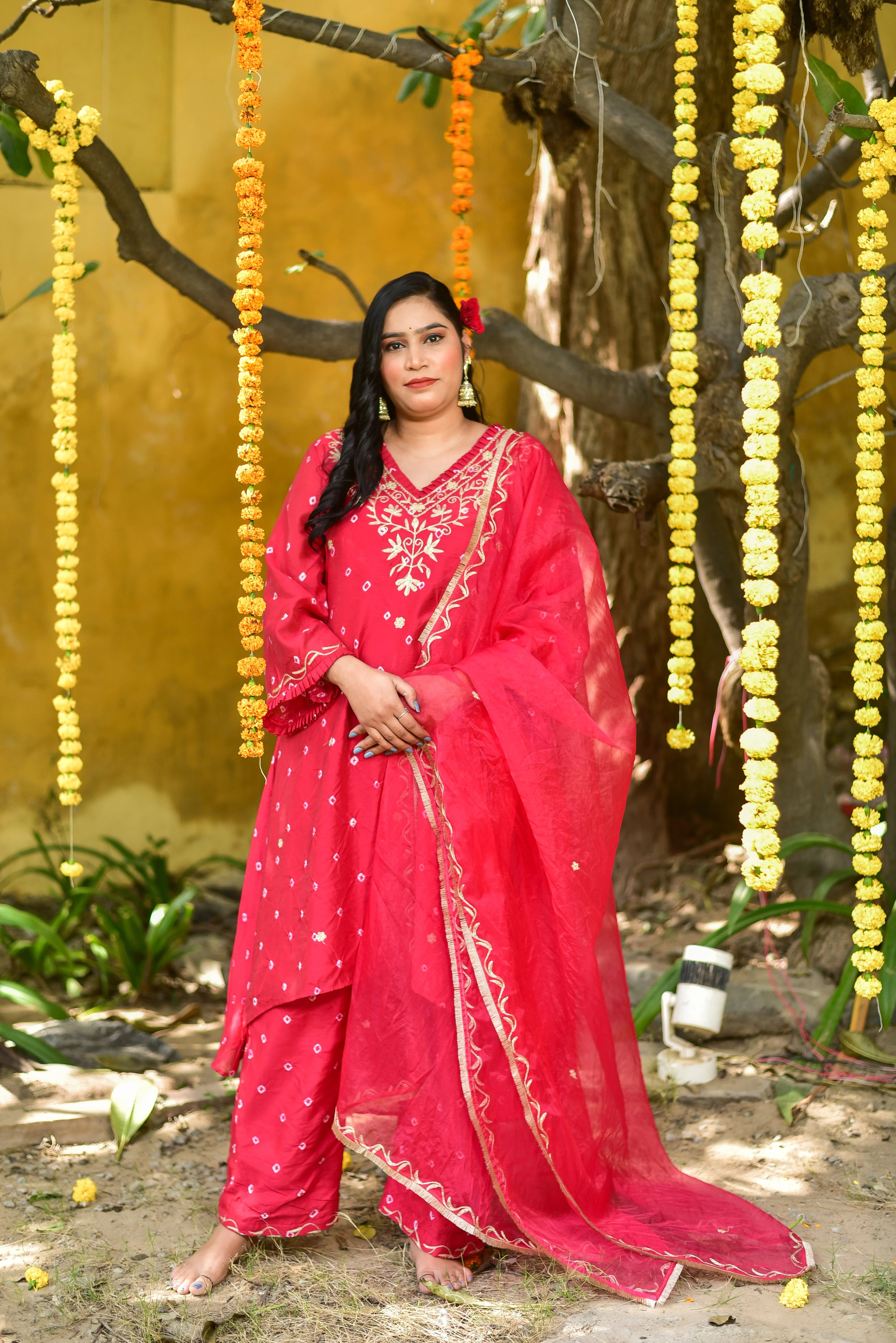 Elevate Your Style with this Stunning Red Bandhej Asymmetrical Kurta Set
This exquisite ensemble is crafted from luxurious fabric, showcasing a perfect blend of traditional craftsmanship and modern design. The red bandhej print adds a pop of color, while the asymmetrical kurta with a V-neck and flared sleeves creates a flattering silhouette. The matching pants feature a comfortable fit and a stylish flair at the bottom.