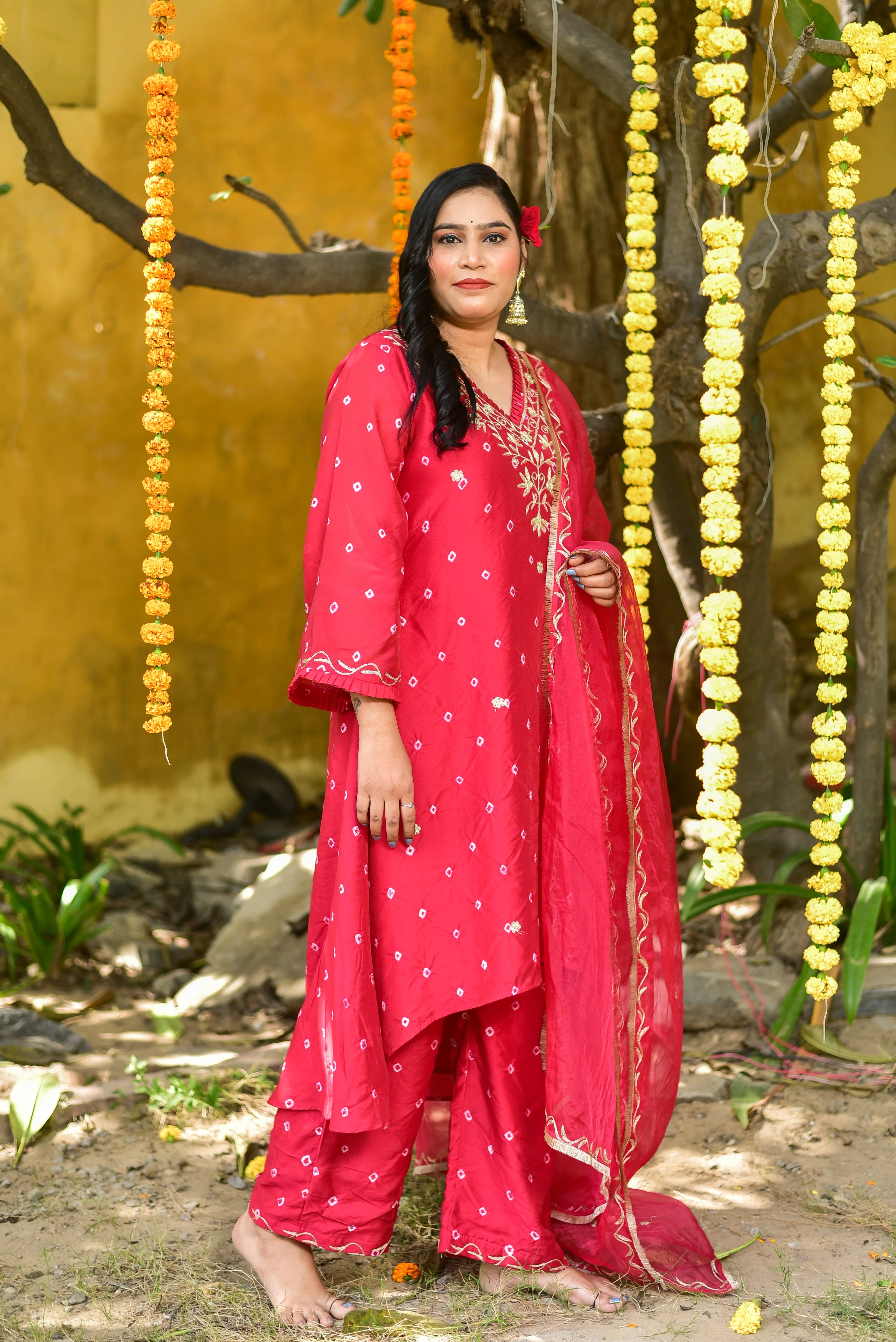 The red Bandhej asymmetrical kurta set is a stunning piece of clothing that combines traditional Indian craftsmanship with modern style. The intricate tie-dye artistry is hand-crafted, making each piece unique and special. The asymmetrical design adds a touch of contemporary sophistication, while the vibrant red color captures the festive spirit. This elegant and trendy ensemble is perfect for making a statement at any celebration.