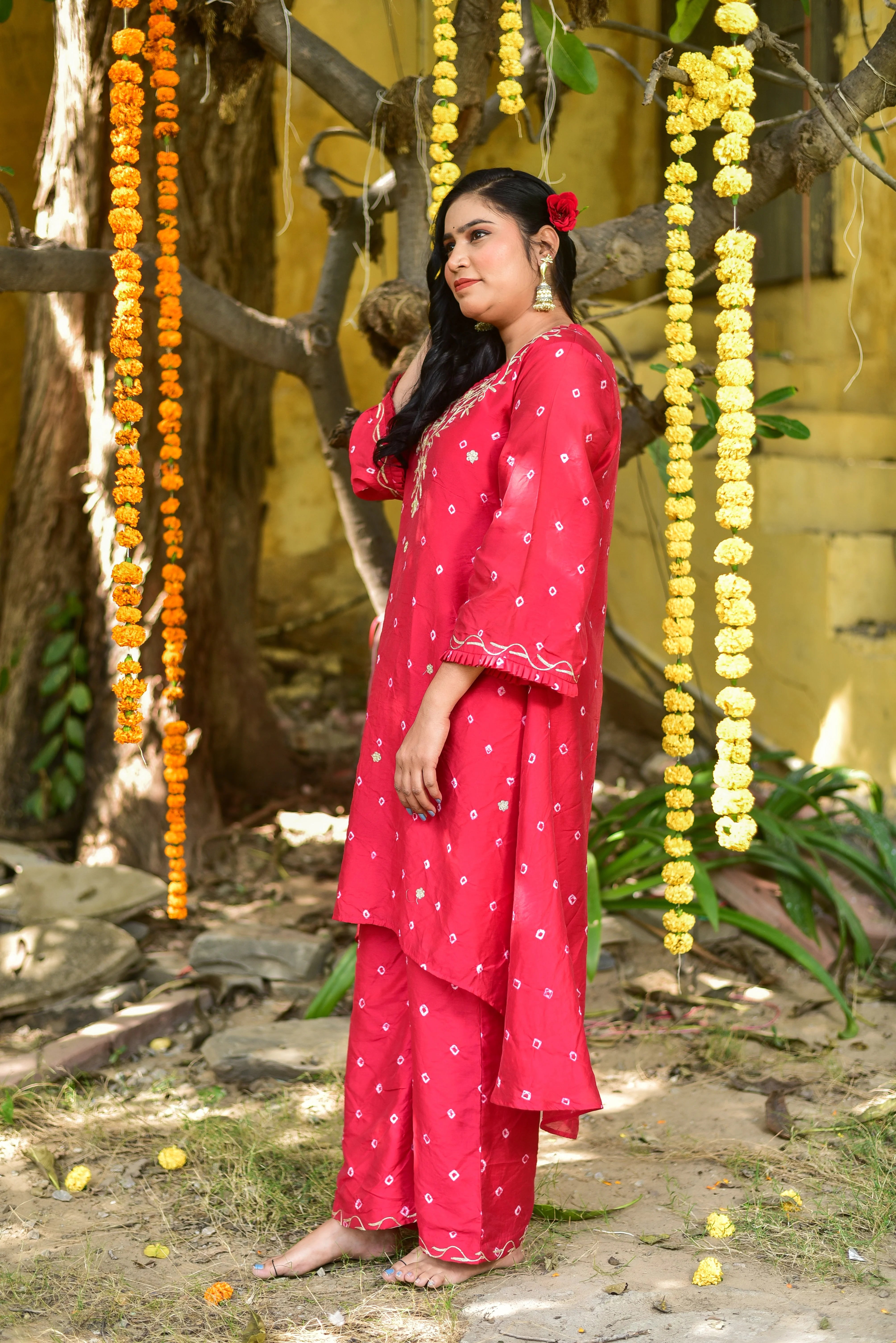 The red Bandhej asymmetrical kurta set is a stunning piece of clothing that combines traditional Indian artistry with modern design elements. The vibrant red color is a perfect representation of the festive spirit, while the asymmetrical cut adds a touch of contemporary sophistication. The intricate tie-dye artistry on the fabric creates a unique and eye-catching pattern, making this outfit perfect for special occasions or everyday wear.