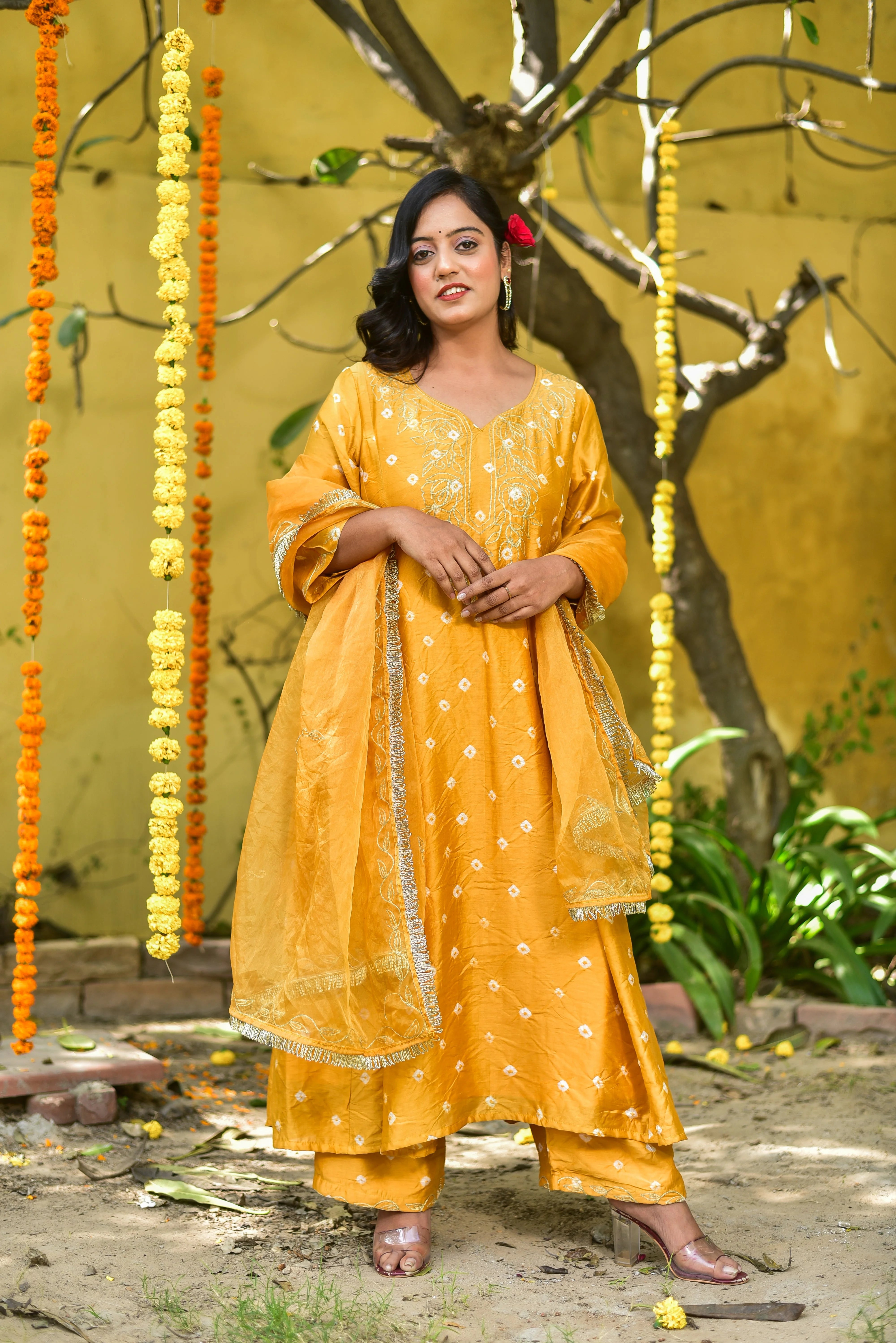 The Mustard Yellow Bhandej Kurta Set is a stunning ensemble that embodies traditional bandhani craftsmanship and vibrant elegance. The luminous mustard hue, reminiscent of sunshine and joy, makes it perfect for auspicious occasions and celebrations. This elegant outfit features a kurta and pant set, crafted from high-quality fabric, with intricate bandhani designs that add a touch of sophistication and style. The set is designed to fit comfortably, ensuring a flattering silhouette for any occasion.