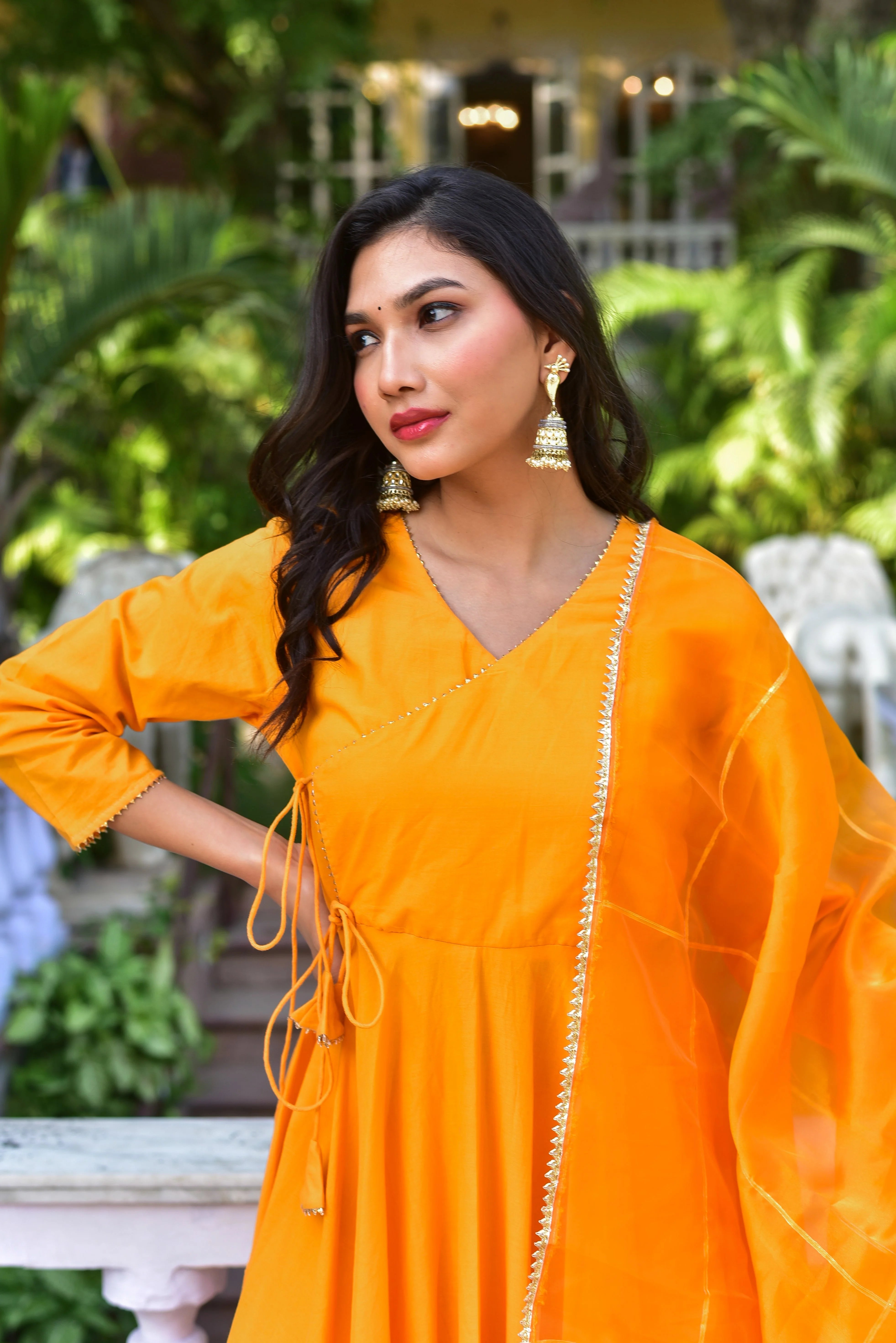 The Haldi Yellow Angrakha Anarkali Set is a stunning piece of traditional Indian clothing that exudes elegance and sophistication. This exquisite ensemble features a vibrant haldi yellow hue, crafted from luxurious fabrics such as silk or organza, which adds a touch of opulence to any occasion.
The Angrakha style of the dress is characterized by its loose, flowing silhouette and intricate detailing, including a drawstring waist that cinches at the front, creating a flattering and feminine silhouette.