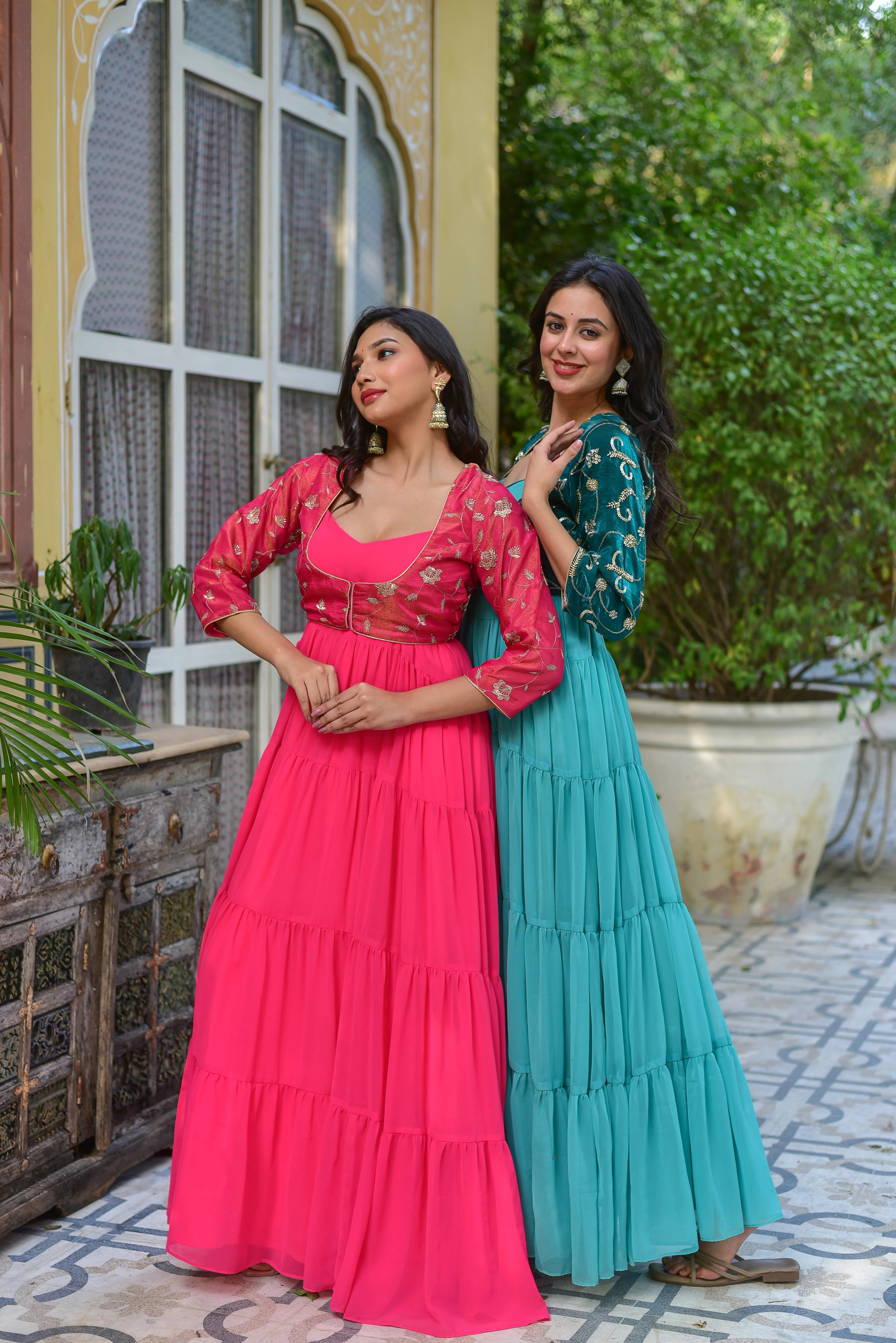 The image showcases a stunning pink tiered dress ensemble, exuding elegance and sophistication. The flowing georgette dress features three tiers of delicate ruffles, creating a beautiful movement with every step. The dress is paired with a coordinating jacket, adorned with intricate floral embroidery on the sleeves and a vibrant pink hue that perfectly complements the dress.
This exquisite ensemble is perfect for making a statement at any celebration, from weddings to formal events.
