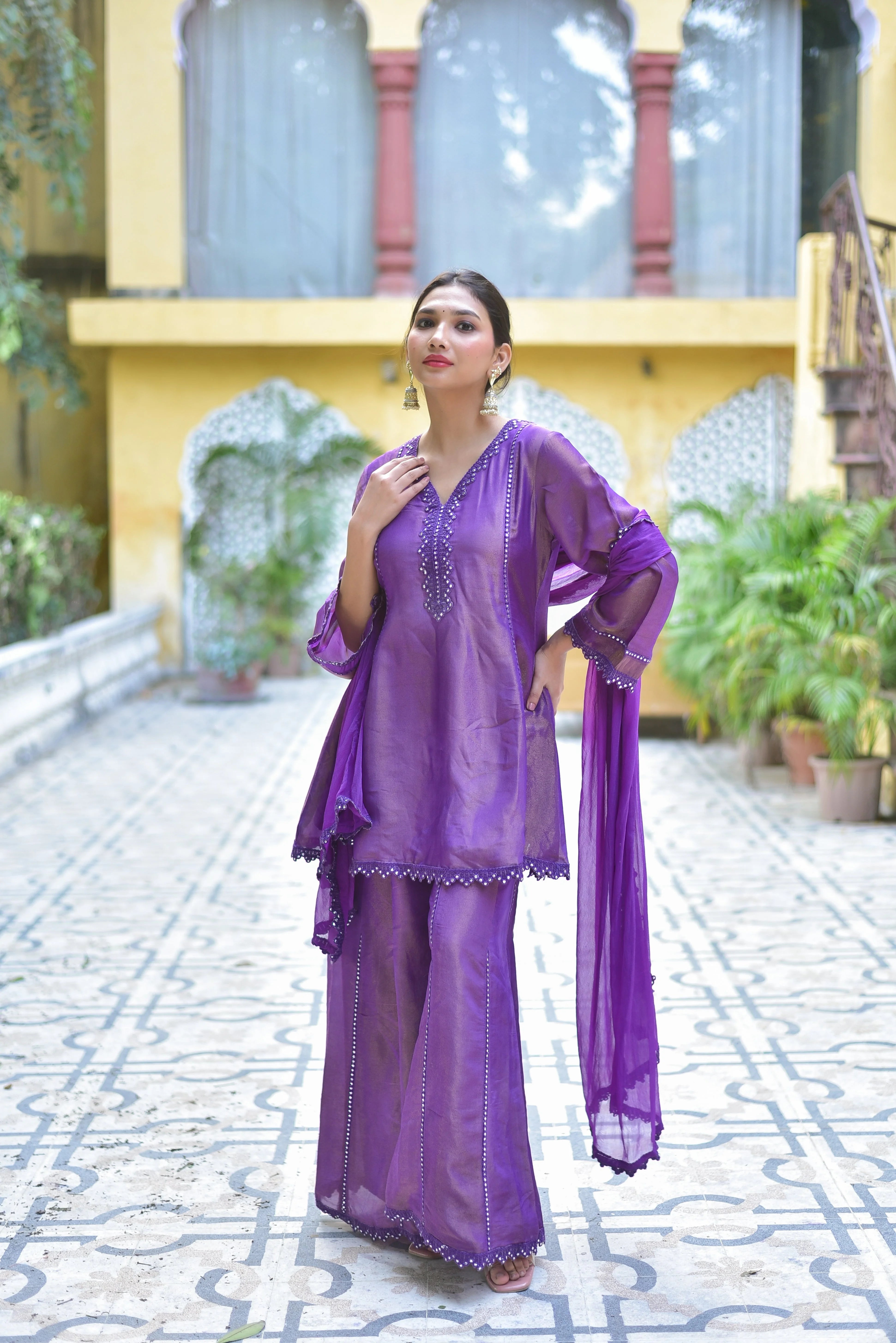 The Purple Zari Silk Kurta Sharara Set is a masterpiece of traditional Indian craftsmanship, seamlessly blending timeless elegance with contemporary grace. This exquisite ensemble is designed for the woman who appreciates regal luxury, making it perfect for festive occasions, celebrations, and special gatherings.
The kurta, crafted from luxurious zari silk, exudes opulence with its rich purple hue and intricate zari embroidery.