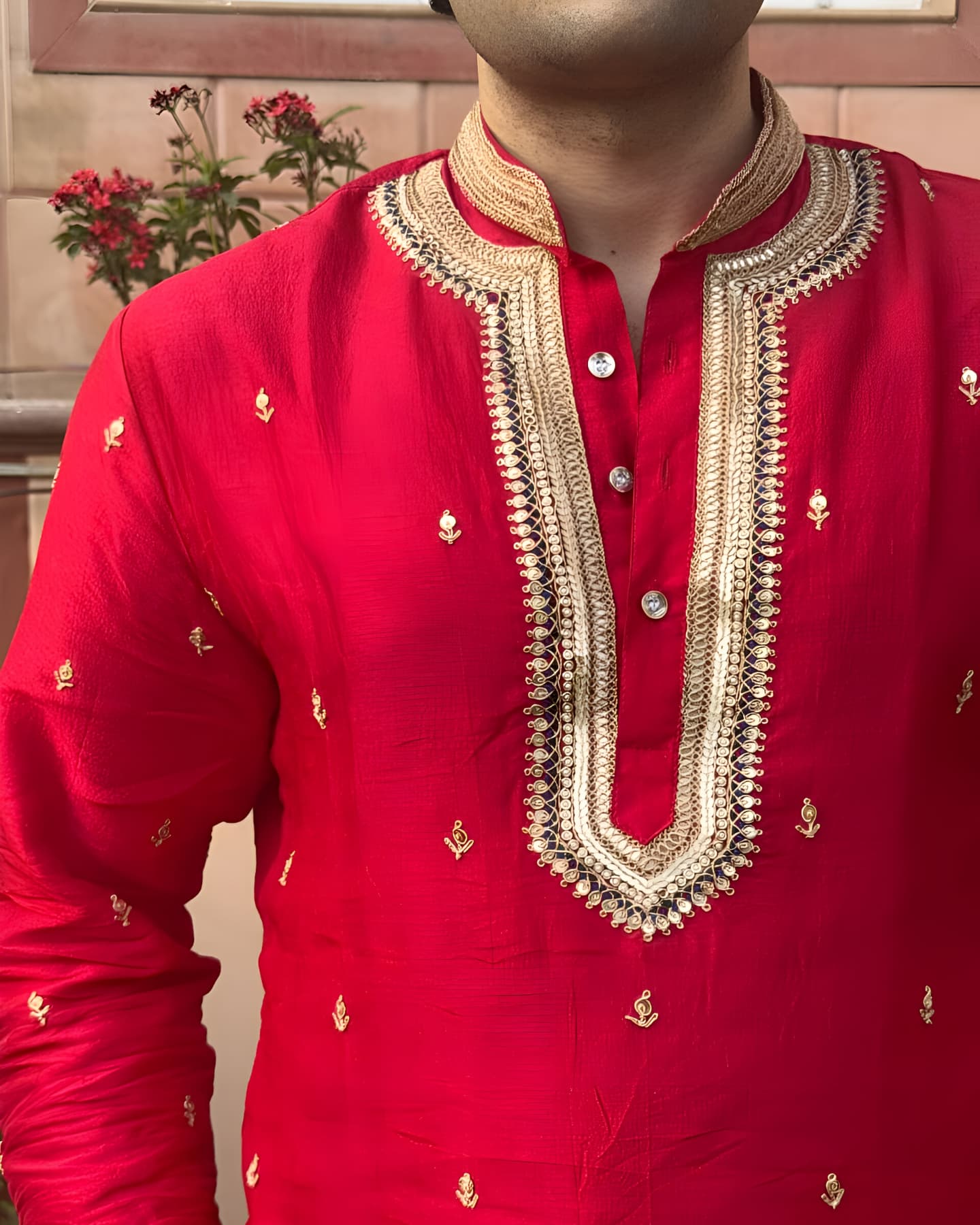 Red traditional outfit with gold embroidery on a neutral background