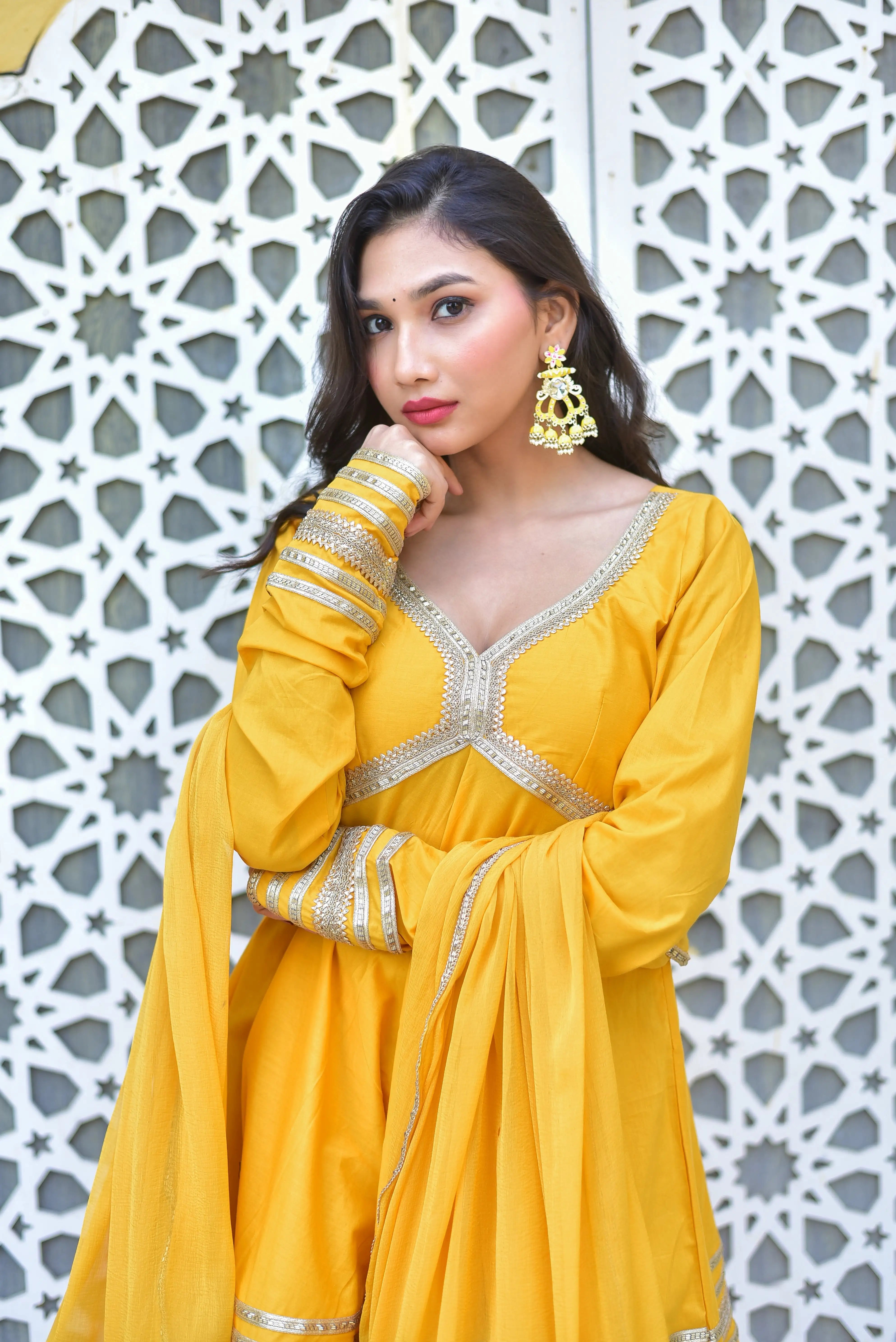 The image showcases a stunning peet amber sharara suit set, exuding elegance and sophistication. The rich mustard-yellow hue is a timeless choice for festive occasions, radiating joy, prosperity, and vibrant energy. The ensemble features intricate silver embroidery on the bodice and sleeves, adding a touch of refinement and luxury. The long-sleeved peet amber sharara suit set is complemented by a matching dupatta, creating a cohesive and stylish look.