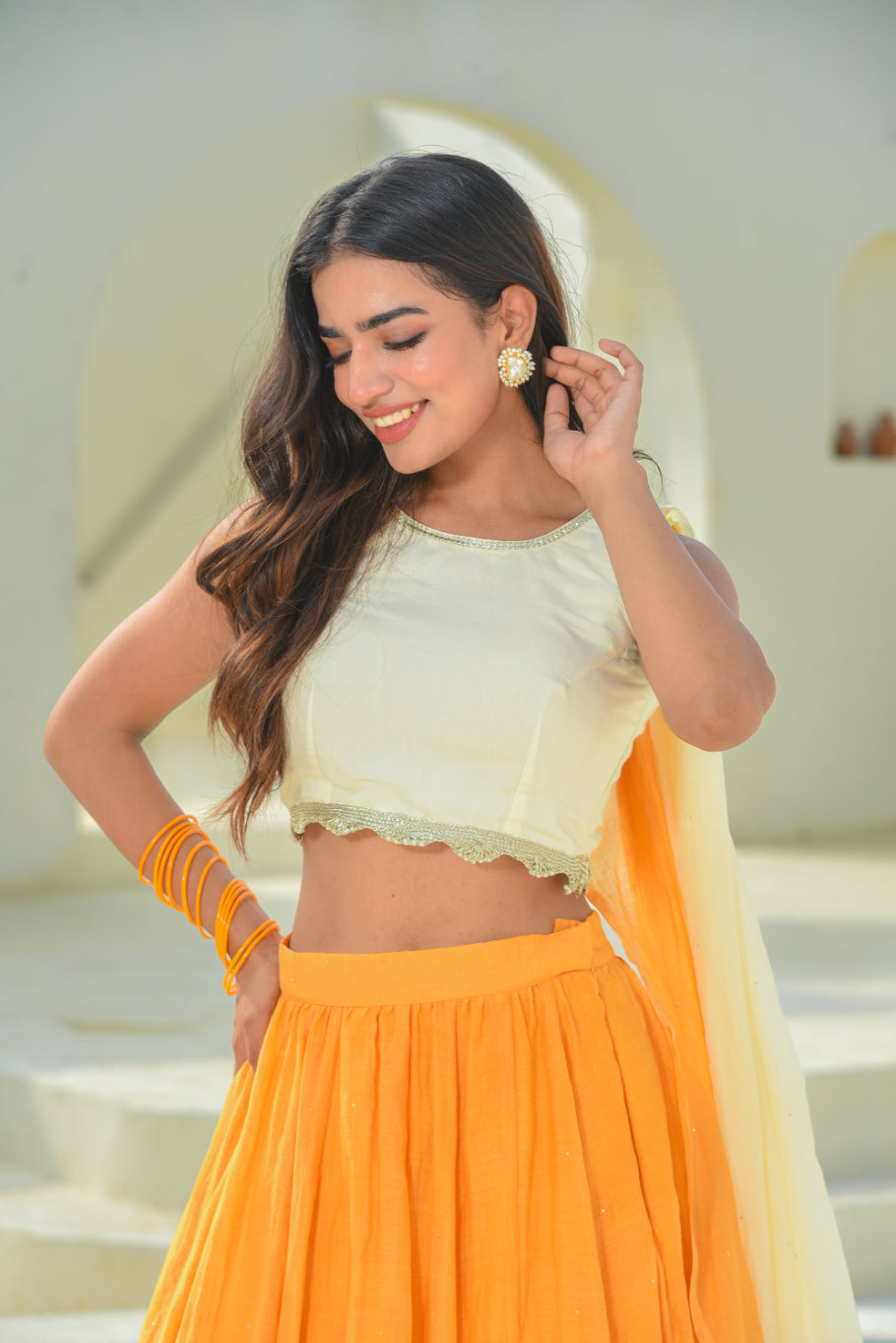 Woman in a yellow and orange traditional outfit with a blurred background