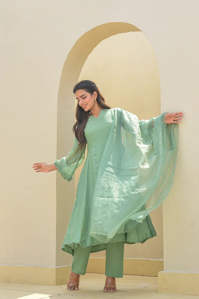 The Mukesh Work A-line Kurta Set by Asya by Saroj Jain is a stunning example of traditional Indian elegance, crafted from premium Mal Chanderi fabric. This exquisite set features an A-line kurta adorned with intricate, hand-crafted Mukesh work that catches the light and adds a touch of sophistication to any occasion. The set is completed by a matching dupatta, adding a pop of color and texture to the overall look.
