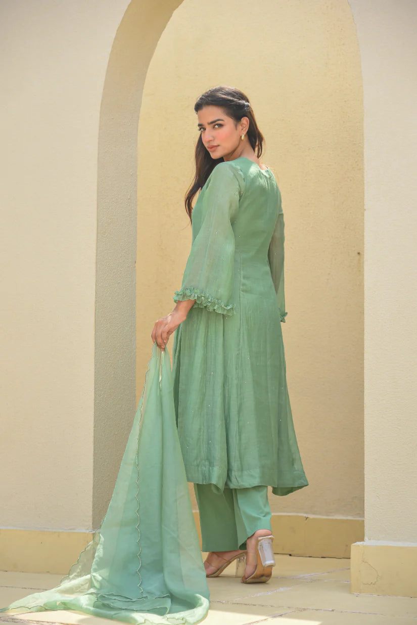 The Mukesh Work A-line Kurta Set by Asya by Saroj Jain is a stunning piece of artistry, crafted from premium Mal Chanderi fabric. The A-line kurta boasts delicate, hand-crafted Mukesh work that catches the light and adds a touch of elegance to any outfit. The set is completed by matching bottoms and a dupatta, making it a perfect choice for any occasion. With its timeless design and high-quality materials, this set is sure to make a statement and leave a lasting impression.