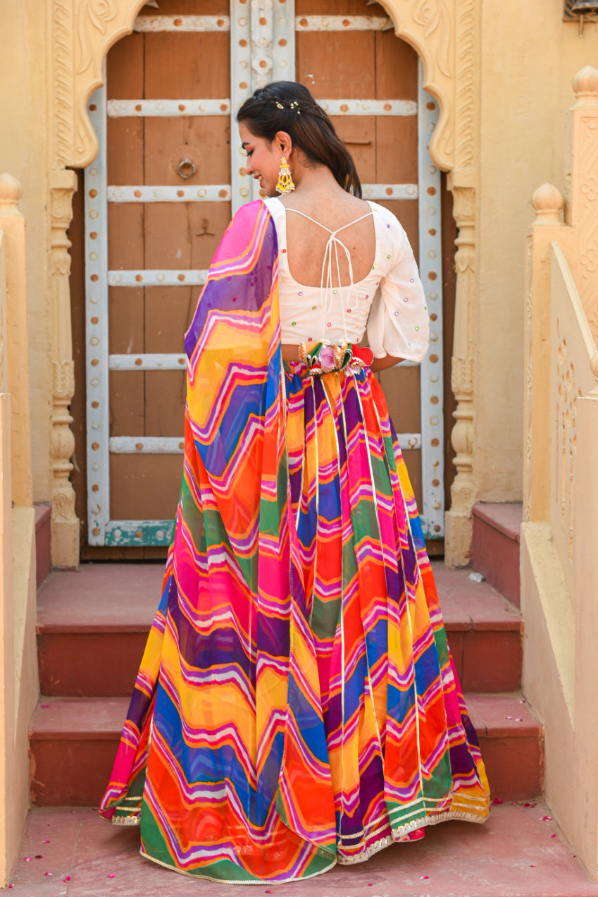 Woman in a colorful dress standing in front of an ornate doorway.