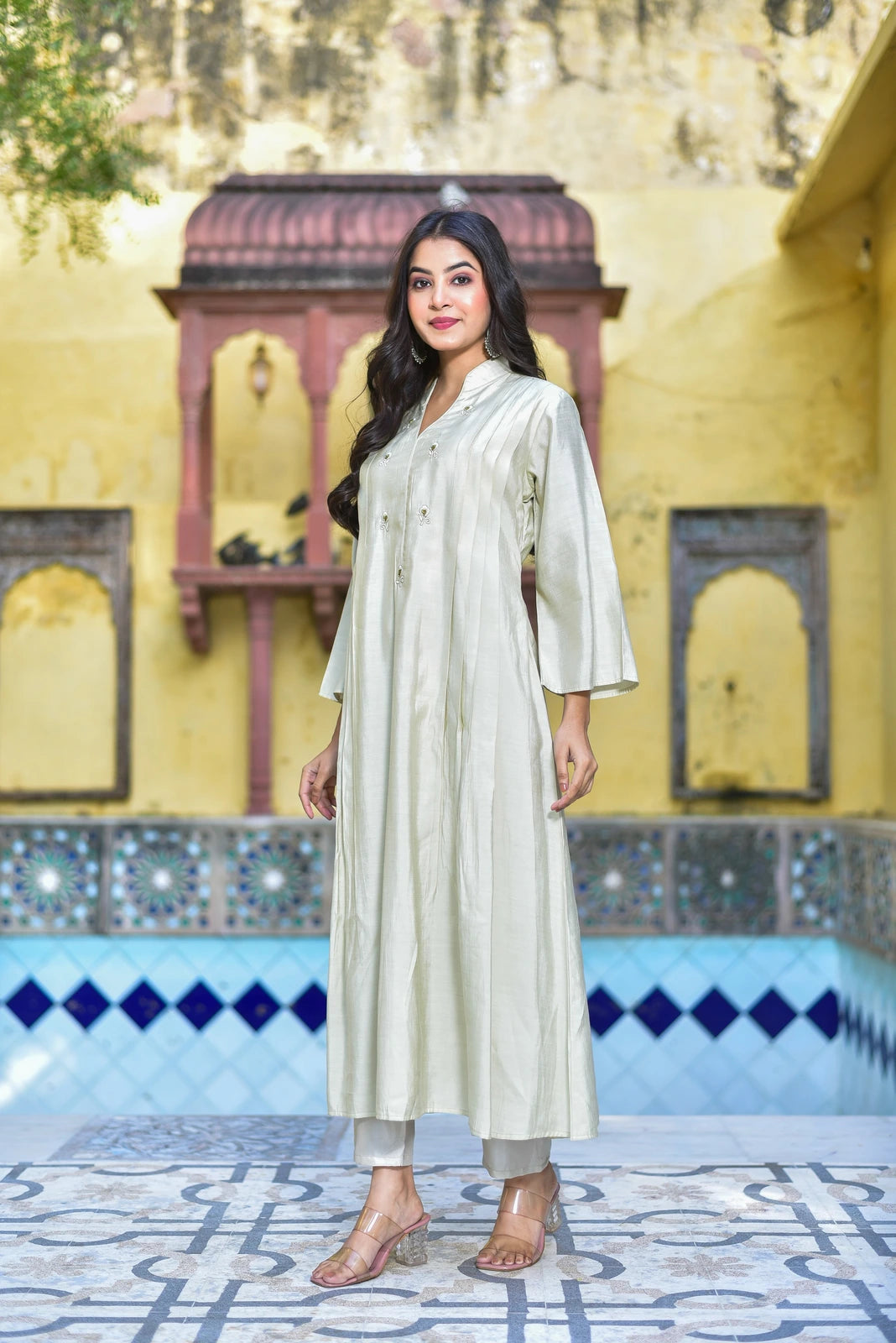 The Creamy Kaju Katli Pleated Kurta Set is a stunning 2-piece ensemble that exudes luxurious elegance. This exquisite outfit features a creamy white kurta with intricate pleats, crafted from high-quality fabric that drapes elegantly on the body. The kurta boasts a classic collar and button-down front, adding a touch of sophistication to the overall design.
Paired with the kurta is a matching pair of pants, creating a cohesive and stylish look.