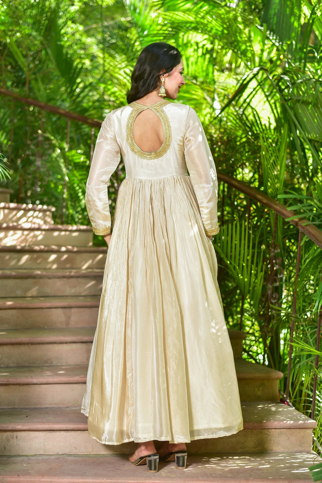 The Shahi Silk Anarkali Set is a luxurious 2-piece ensemble that embodies timeless grace and festive grandeur. The flowing anarkali dress in rich cream zari silk features exquisite gold lace detailing, creating a stunning and elegant look. This set is perfect for special occasions and is sure to make a statement with its regal and sophisticated design. With its high-quality materials and attention to detail, this set is a must-have for anyone looking to elevate their fashion game.