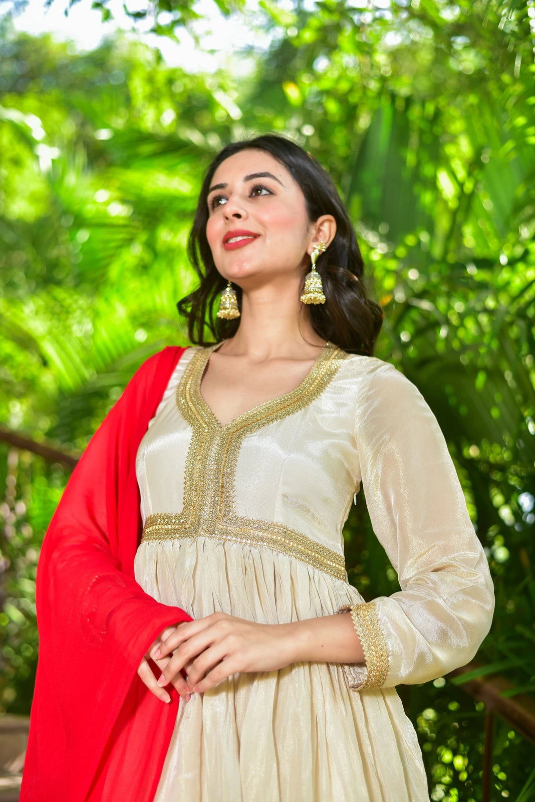 The Shahi Silk Anarkali Set is a luxurious 2-piece ensemble that embodies timeless grace and festive grandeur. This stunning set features a flowing anarkali dress in rich cream zari silk with exquisite gold lace detailing, paired with a matching dupatta. The dress is crafted from high-quality silk fabric, ensuring a smooth and comfortable fit. The intricate gold lace detailing adds a touch of opulence and sophistication, making this set perfect for special occasions such as weddings and festivals.