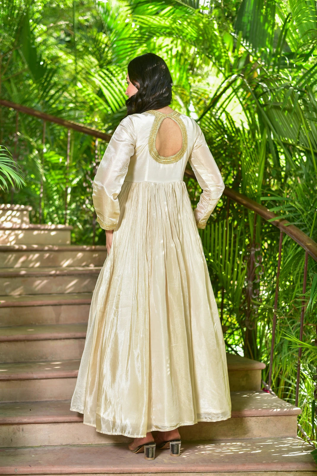 The Shahi Silk Anarkali Set is a luxurious 2-piece ensemble that embodies timeless grace and festive grandeur. This stunning set features a flowing anarkali dress in rich cream zari silk with exquisite gold lace detailing, paired with a matching dupatta for a complete and elegant look. The anarkali dress boasts a comfortable fit with a V-neckline and long sleeves, while the dupatta adds a touch of sophistication with its intricate gold lace border.