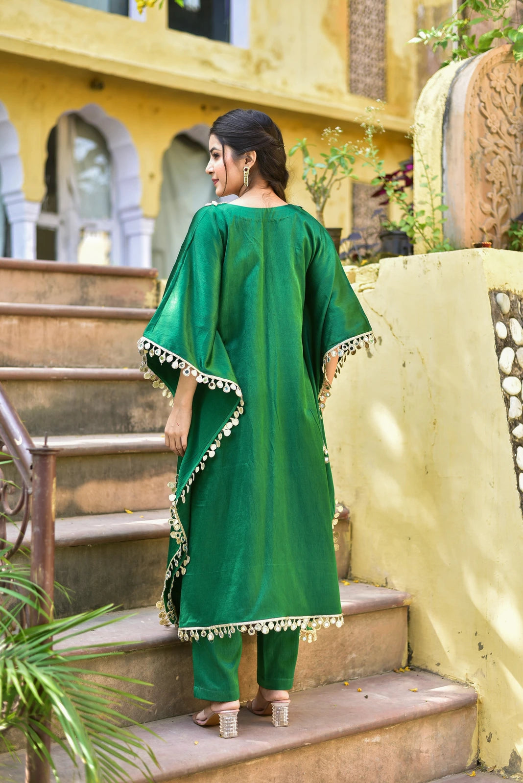 The Forest Glaze Mirror Work Set is a stunning ensemble that embodies the essence of regal elegance and contemporary ease. Crafted from lustrous Gazzi Satin, this exquisite kaftan set features intricate mirror work detailing that captures the richness of emerald forests, making it a perfect choice for those who appreciate the finer things in life. With its elegant design and luxurious fabric, this set is sure to make a statement at any occasion, whether it's a formal event or a casual gathering.