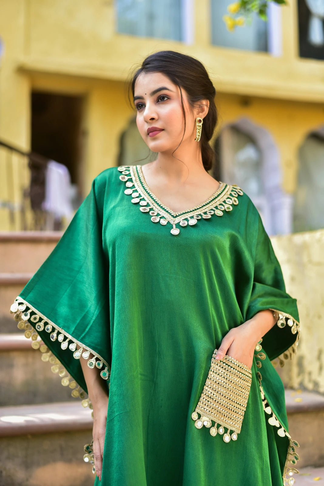 The Forest Glaze Mirror Work Set is a stunning ensemble that exudes regal elegance and contemporary ease. Crafted in lustrous Gazzi Satin, this exquisite kaftan set captures the richness of emerald forests with intricate mirror work detailing that catches the light beautifully. The set features a flowing kaftan with a V-neckline and 3/4 sleeves, adorned with delicate mirror work embroidery that adds a touch of sophistication to the overall design.