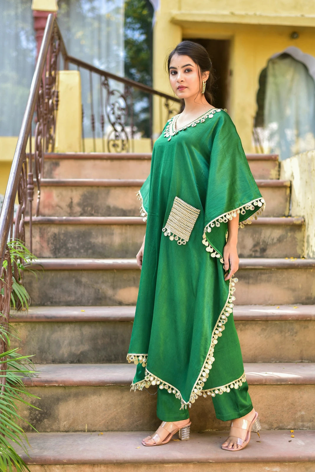 The Forest Glaze Mirror Work Set is a stunning ensemble that embodies regal elegance and contemporary ease. Crafted from luxurious Gazzi Satin, this kaftan set captures the richness of emerald forests with exquisite mirror work detailing that catches the eye. The elegant design and high-quality fabric make it a must-have for any fashion-conscious individual looking to make a statement. With its unique blend of traditional and modern elements, this set is sure to turn heads and leave a lasting impression.