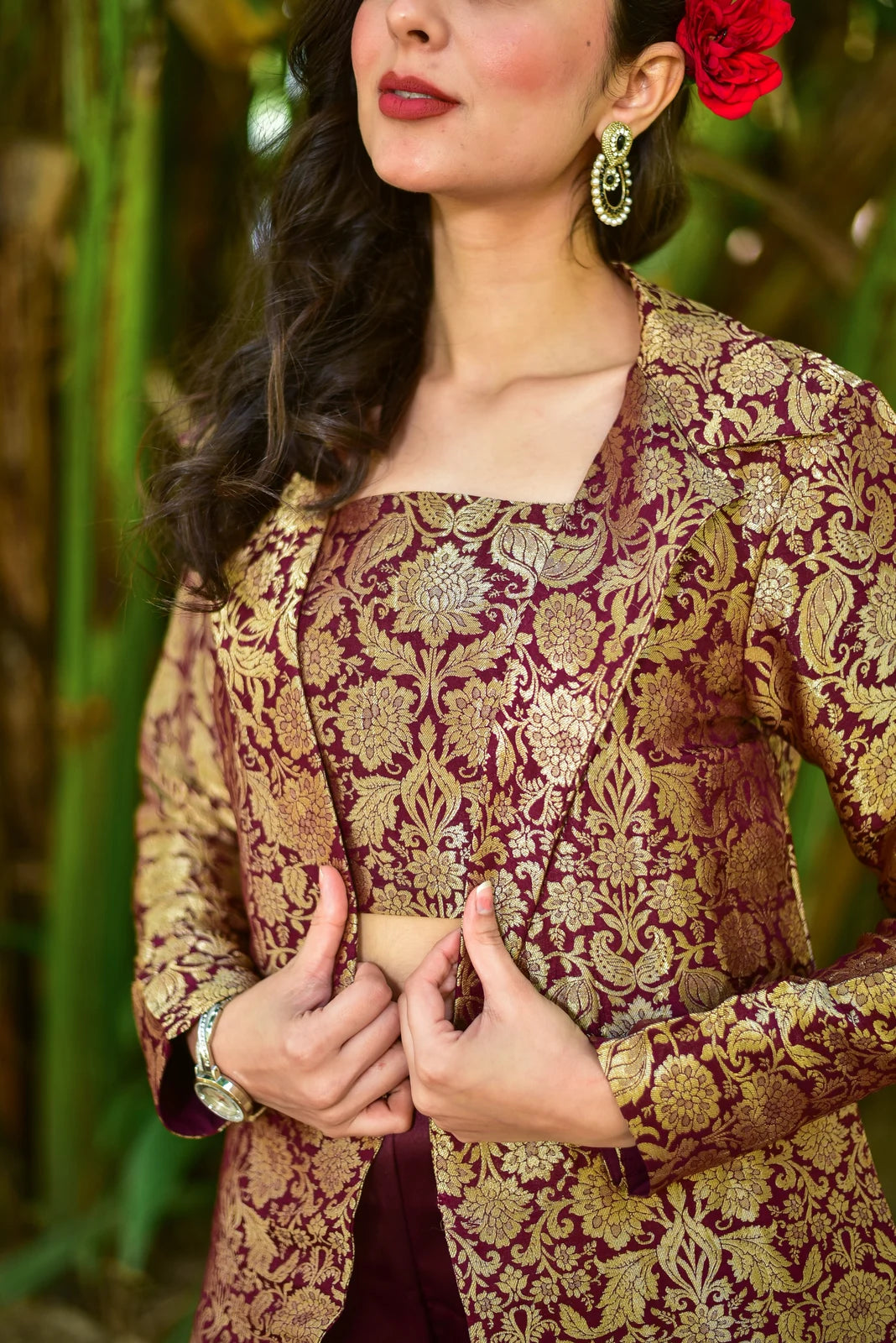 This stunning 3-piece ensemble showcases a harmonious blend of contemporary elegance and traditional opulence. The set includes a brocade blazer, a matching crop top, and a stylish skirt, all crafted from intricately embroidered gold brocade fabric. The full sleeves of the blazer add a touch of sophistication, while the fitted silhouette and rich plum color exude confidence and poise. The crop top complements the blazer with its square neckline and cropped length, creating a chic and modern look.
