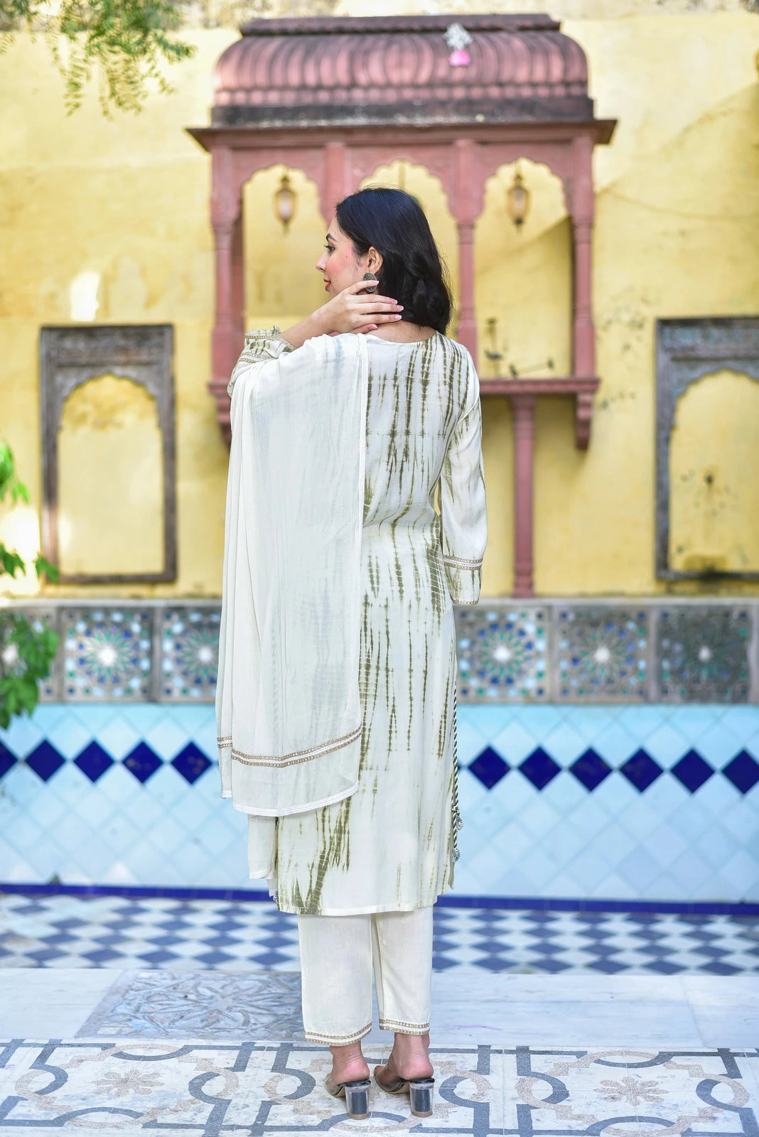 The Moss Green Shibori Straight Kurta Set is a stunning three-piece ensemble that seamlessly blends traditional tie-dye shibori artistry with contemporary grace. The set features a moss green kurta adorned with intricate shibori patterns, complemented by a matching straight-cut pant and a dupatta. The fabric is a luxurious blend of cotton and silk, providing both comfort and elegance. The set is designed to fit perfectly, with a straight silhouette that accentuates the wearer's curves.