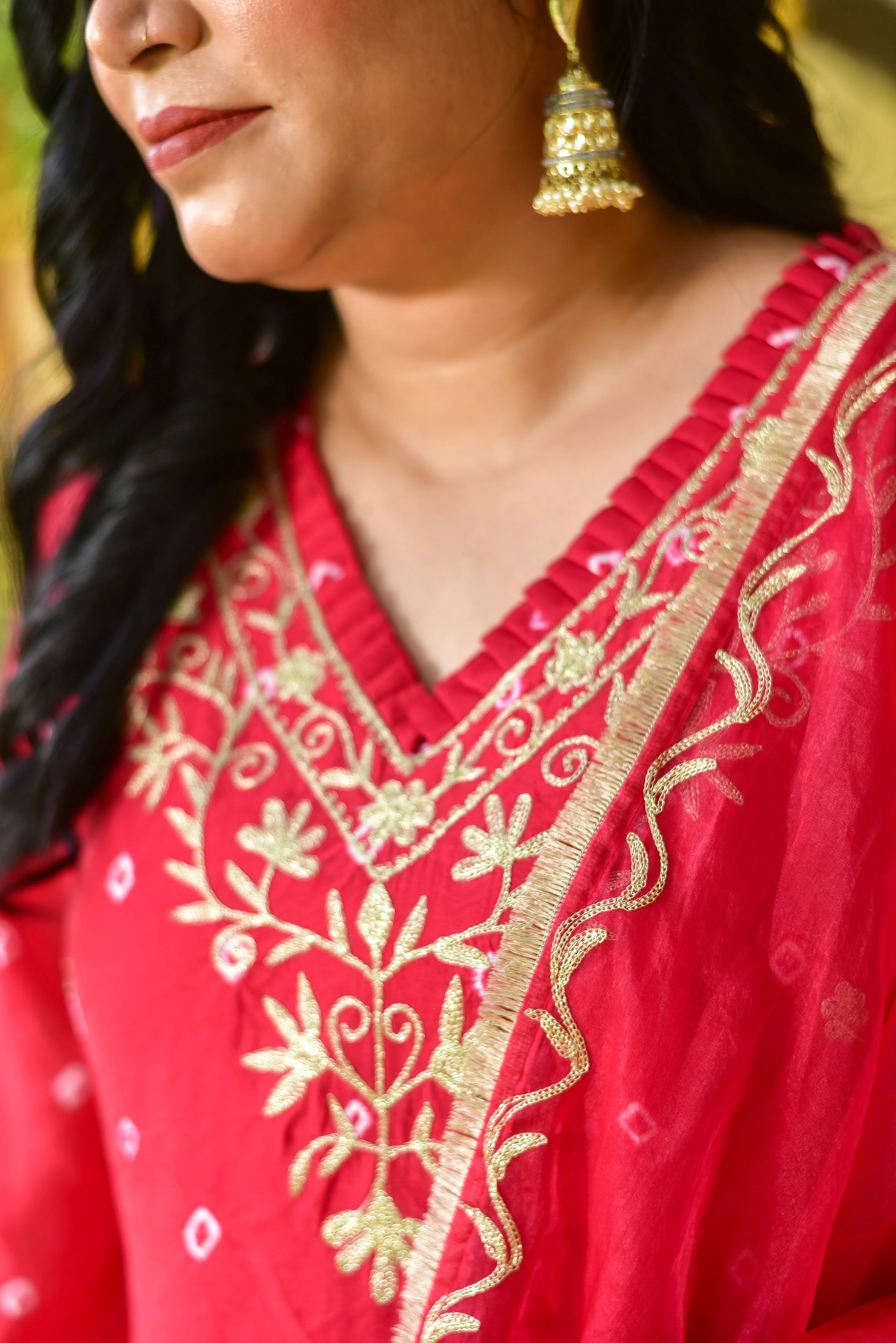 The red Bhandej asymmetrical kurta set is a stunning ensemble that embodies the vibrant spirit of festive celebrations while offering modern silhouette sophistication. Crafted with intricate tie-dye artistry, this hand-crafted piece showcases a unique blend of traditional Bandhej patterns and contemporary design. The asymmetrical kurta features a bold red hue, complemented by elegant gold embroidery that adds a touch of luxury.