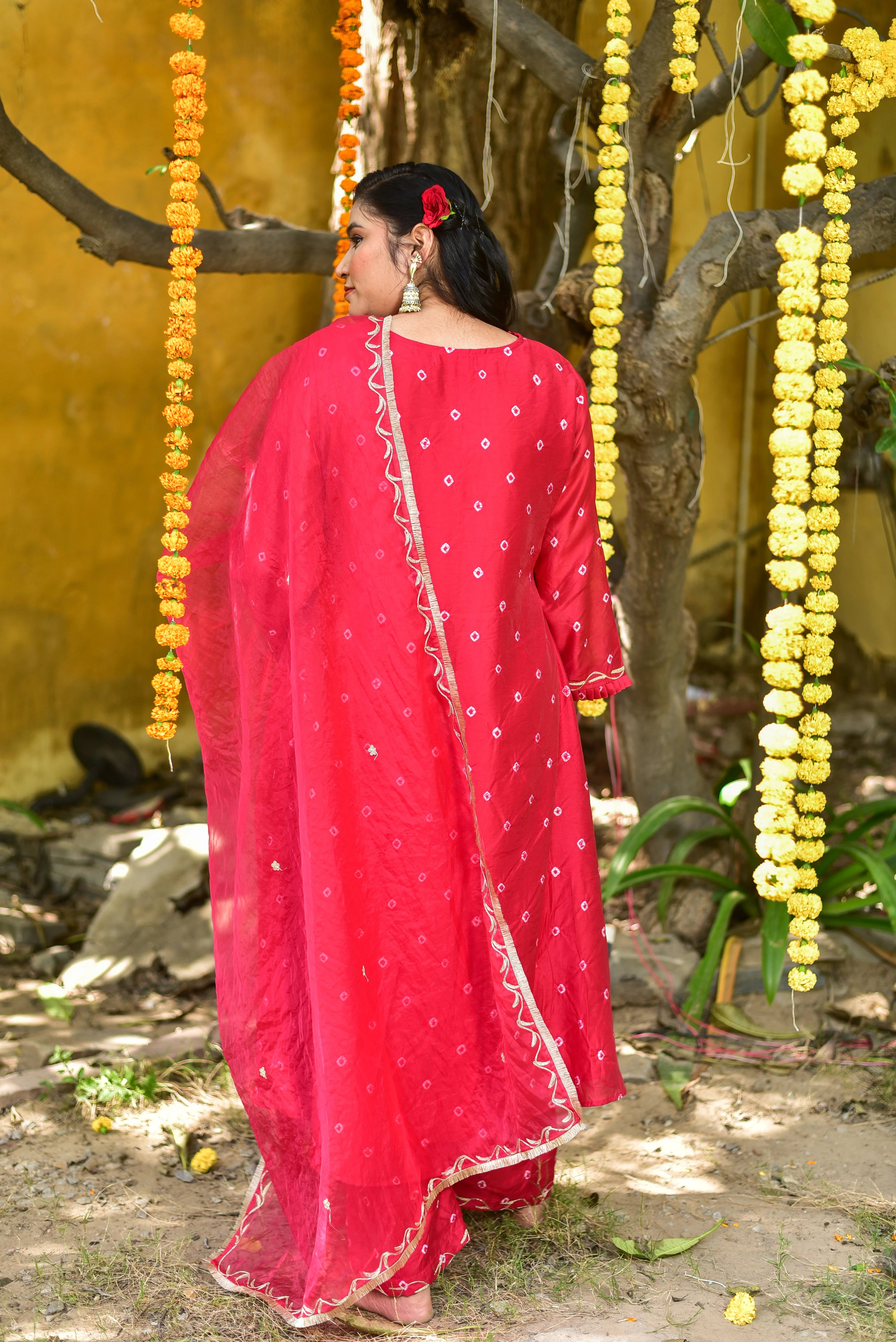 The red Bandhej asymmetrical kurta set is a stunning ensemble that combines traditional tie-dye artistry with modern silhouette sophistication. Crafted from high-quality fabric, this set features intricate Bandhej patterns in a vibrant red hue, creating a unique and eye-catching design. The asymmetrical hemline adds a contemporary twist to the traditional kurta, making it perfect for those who want to make a statement at any occasion.