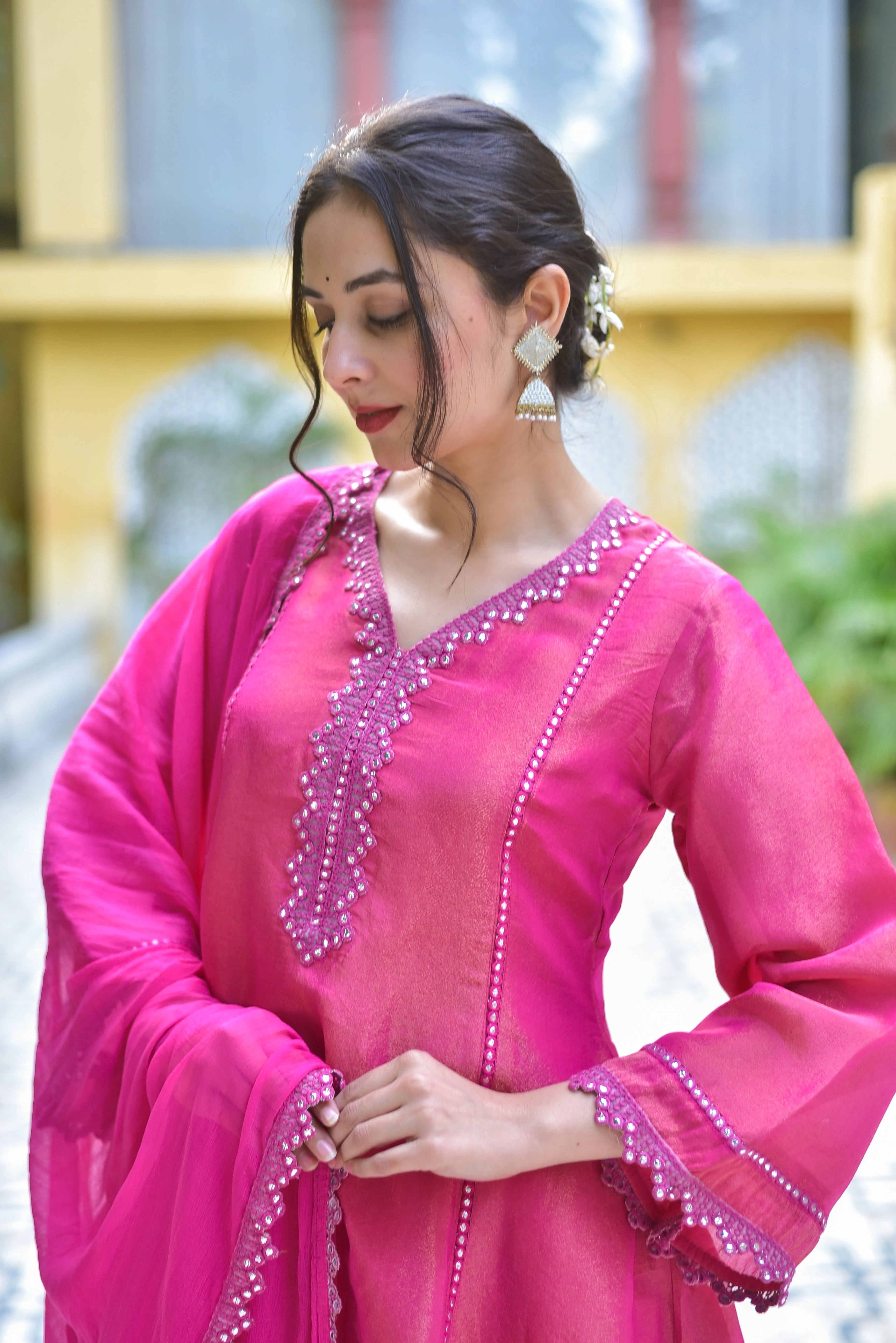 The image showcases a stunning pink zari silk kurta sharara set, perfect for making a statement at any occasion. The intricate zari work and delicate pearl detailing on the sleeves and neckline add an air of elegance, while the flowing sharara pants create a beautiful silhouette. This exquisite ensemble is sure to turn heads and make you feel like royalty. With its timeless design and luxurious fabric, this pink zari silk kurta sharara set is a must-have for any fashion-forward individual.