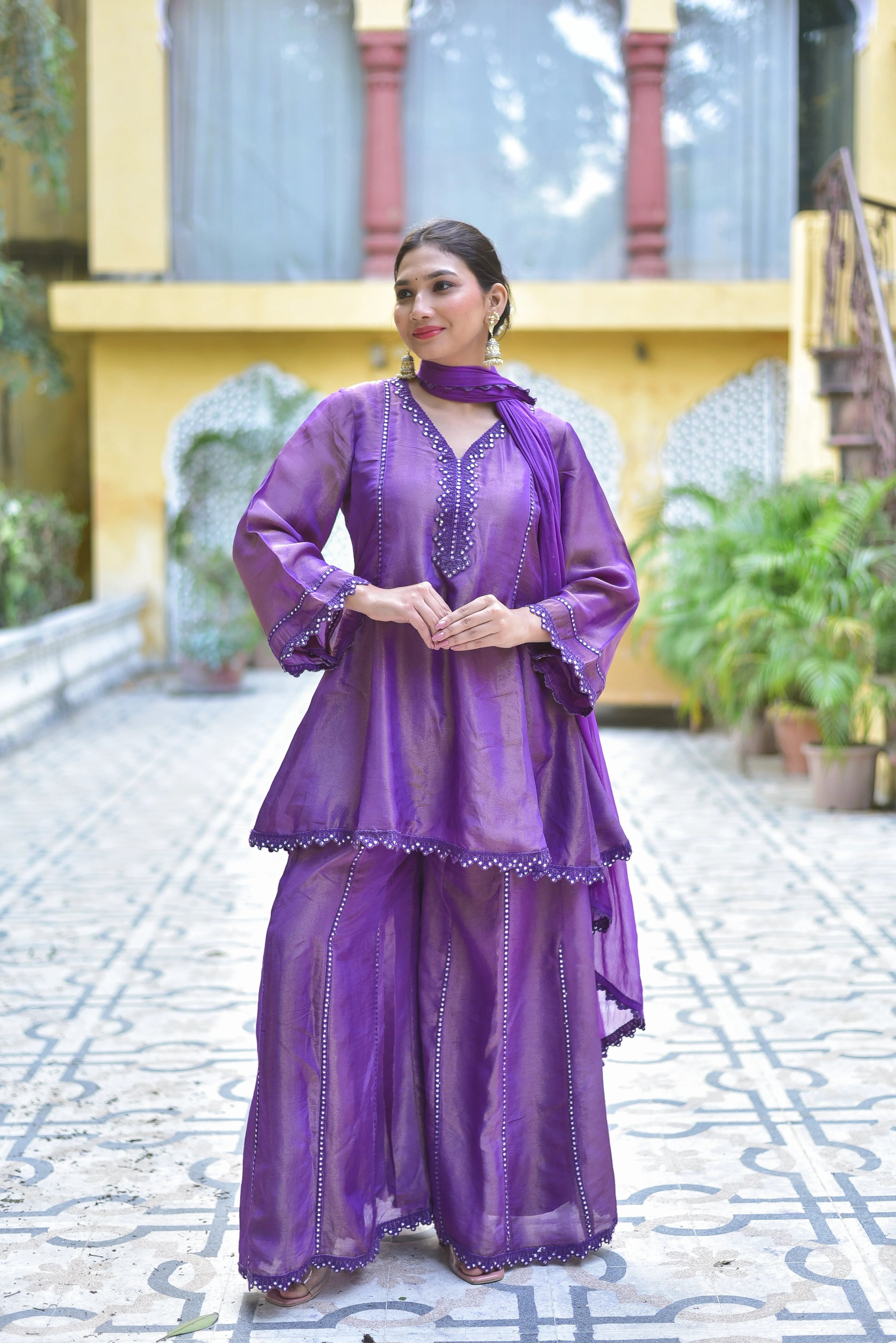 The Purple Zari Silk Kurta Sharara Set is a stunning and elegant ensemble that exudes traditional craftsmanship and contemporary grace. This exquisite piece is designed for the woman who appreciates regal luxury, making it perfect for festive occasions, celebrations, and special gatherings.

The set features a beautiful purple kurta crafted from luxurious zari silk fabric, adorned with intricate zari work that adds a touch of sophistication and opulence.