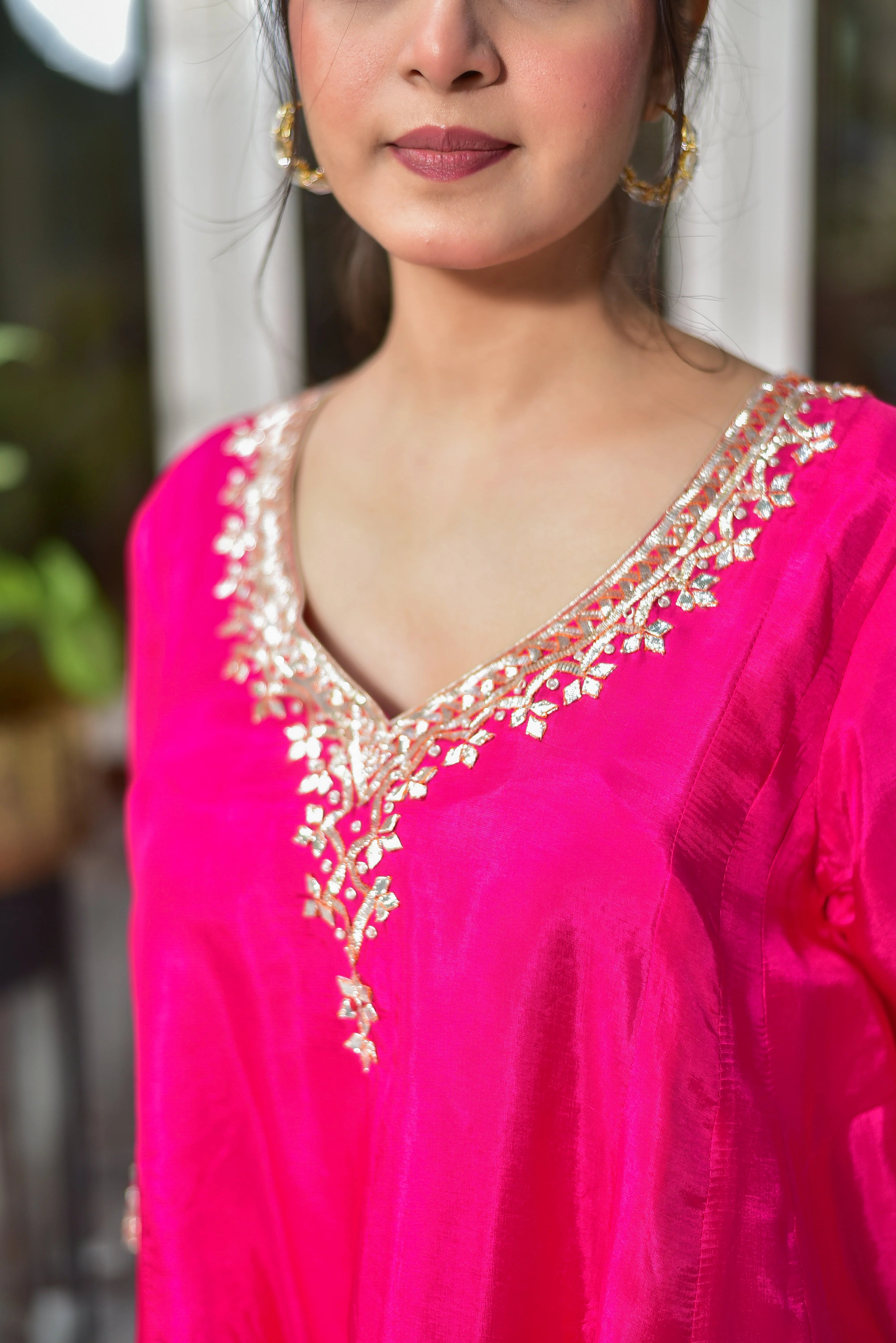 The image showcases a stunning Rani Pink Punjabi Style Kurta & Dhoti Set, exuding elegance and tradition. The vibrant pink color, combined with the luxurious silk fabric, creates a regal and sophisticated look. The intricate gold embroidery adorning the neckline and hem adds a touch of opulence, while the fluid silhouette of the kurta and dhoti creates a comfortable and flattering fit.