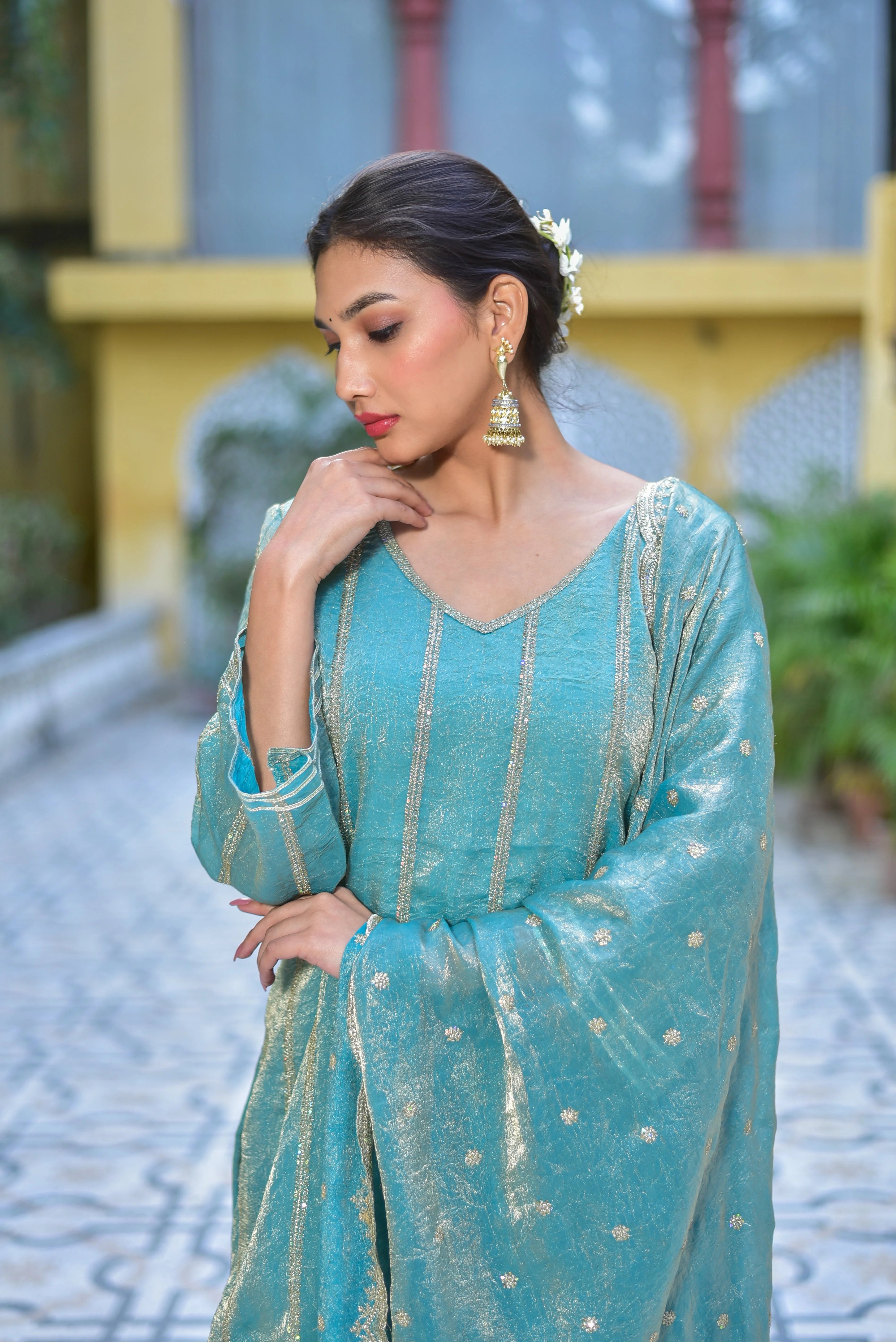 The image showcases a stunning Sea Green Kurta Sharara Set, exuding elegance and sophistication. The kurta's V-neckline and three-quarter sleeves create a flattering silhouette, while the intricate gold embroidery adds a touch of luxury. Paired with a matching sharara and a flowing dupatta, this ensemble is perfect for making a statement at any occasion. Crafted from high-quality fabric, this set is not only visually appealing but also comfortable to wear.