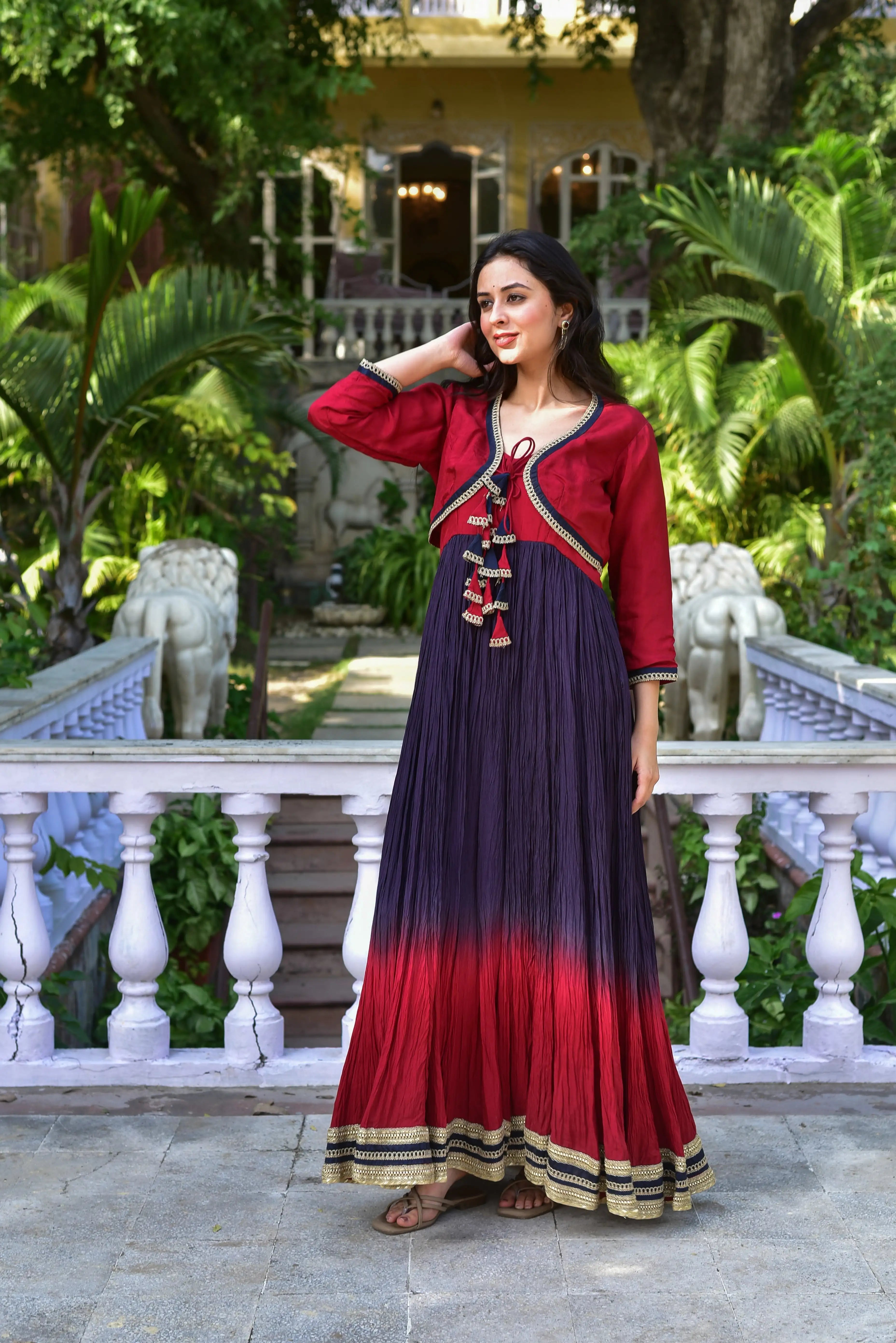 The Twilight Ombre Gown With Jacket

This stunning ensemble showcases a breathtaking ombre effect on luxurious silk fabric, capturing the magic of twilight. The gown features a rich red to deep purple gradient, adorned with intricate gold and black trim details that add an air of sophistication. The jacket, with its deep red hue and black trim, complements the gown perfectly, creating a harmonious balance of colors.