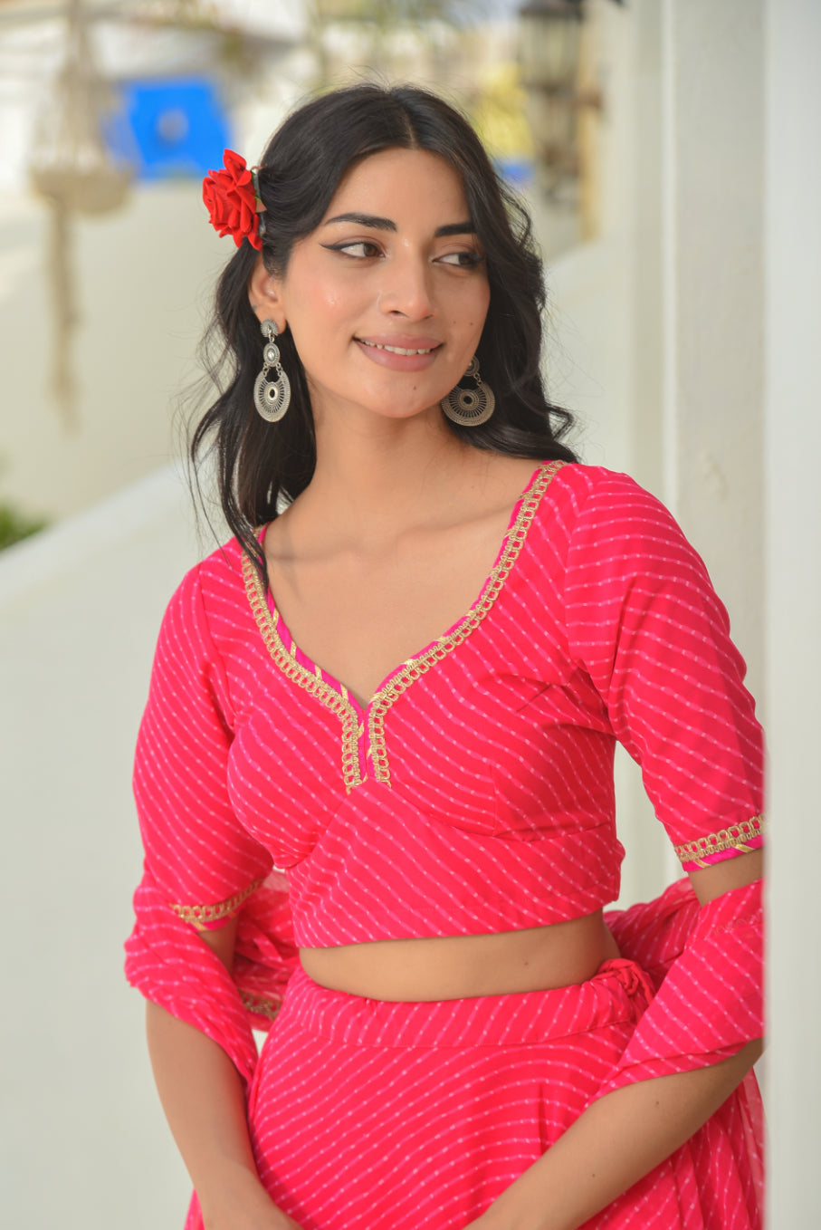 Woman in a bright pink traditional outfit with a blurred background