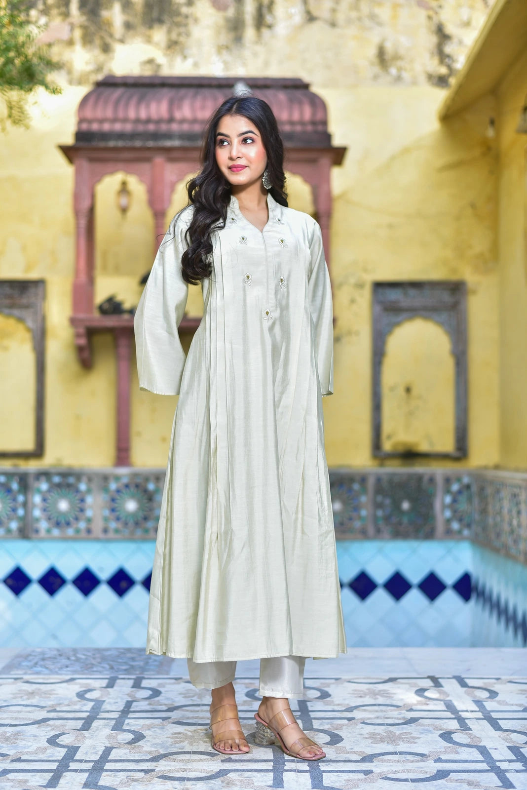The Creamy Kaju Katli Pleated Kurta Set is a stunning 2-piece ensemble that exudes elegance and sophistication. This exquisite outfit features a creamy white color, complemented by a pleated design that adds a touch of refinement to the overall look. The kurta boasts a classic collar and button-down front, creating a sense of structure and formality, while the pants provide a comfortable and relaxed fit.