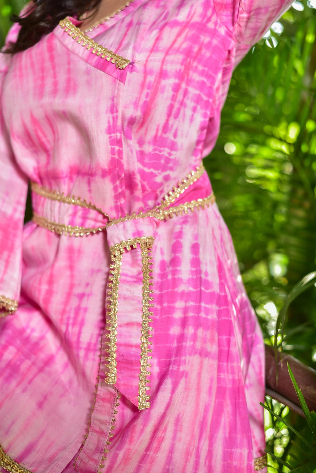 The Roseberry Pink Shibori Co-ord Set is a stunning 3-piece ensemble featuring exquisite hand tie-dye shibori patterns. This contemporary set combines traditional artisan techniques with modern silhouettes, perfect for festive occasions and special events. The set includes a top, bottom, and belt, all made from high-quality fabric that drapes elegantly on the body. The tie-dye pattern adds a unique touch of elegance and sophistication, making this set perfect for those who want to make a statement.