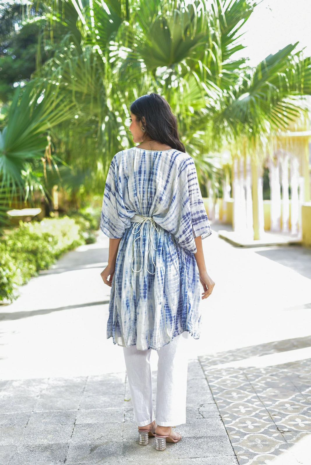 The Indigo Cloud Shibori Kaftan Set is a stunning three-piece ensemble that embodies elegance and sophistication. This exquisite set features a hand tie-dye shibori pattern in soothing blue and white hues, creating a mesmerizing visual effect. The kaftan itself is crafted from luxurious fabric, ensuring both comfort and style. The set includes a matching top and bottom, designed to complement each other perfectly.