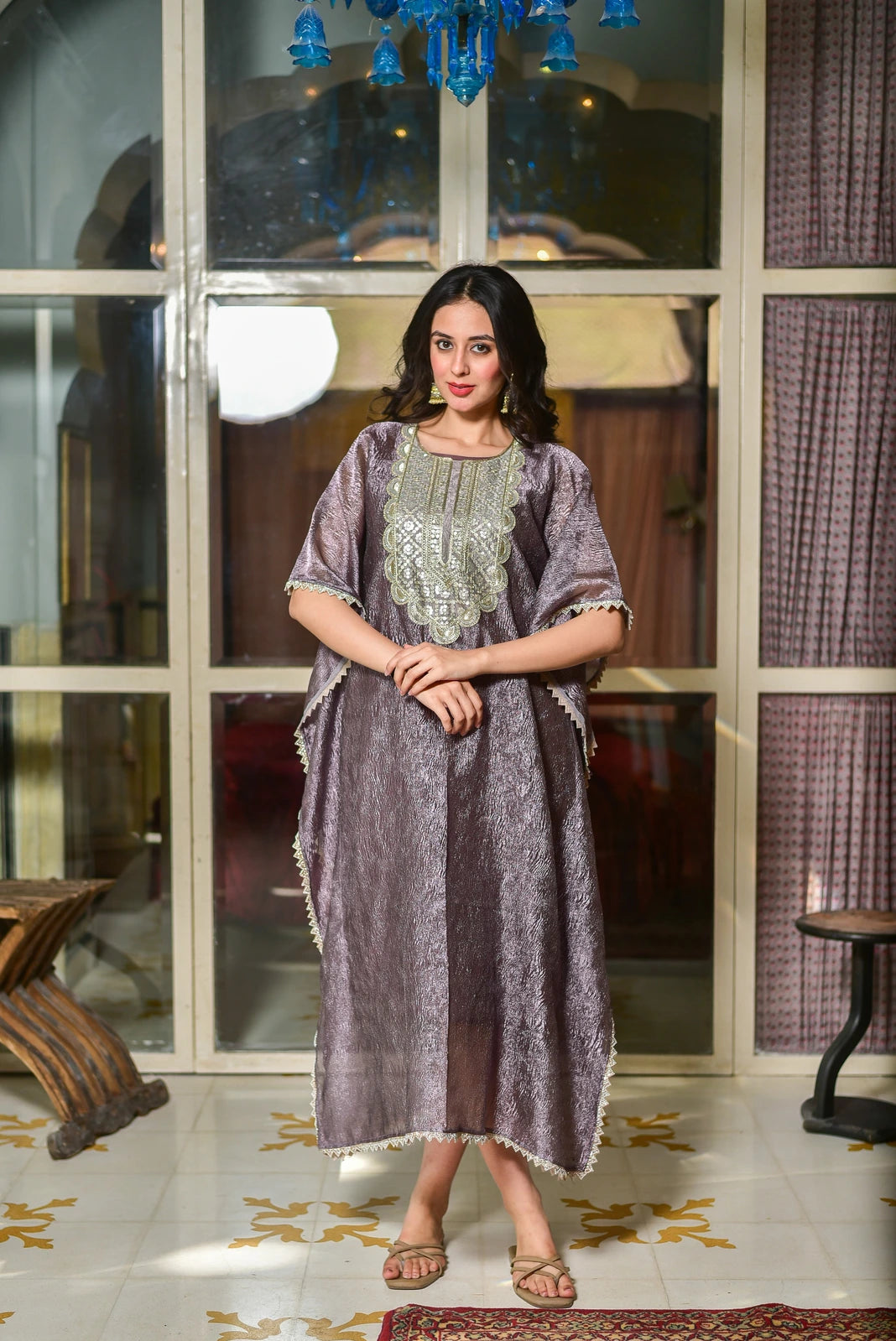 The image showcases a woman posing in a stunning kaftan dress, exuding elegance and sophistication. The dress is crafted from premium moss organza, featuring a sophisticated lavender tone that commands attention. The intricate embroidery on the chest adds a touch of luxury, while the loose, flowing design ensures comfort without sacrificing style.

This product is perfect for those seeking a statement piece that combines contemporary fashion with timeless elegance.