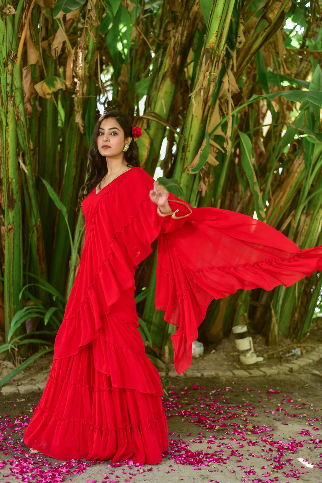 The Regal Red Georgette Sharara Saree Set is a stunning fusion of traditional grace and contemporary design, perfect for weddings, festive celebrations, and special occasions. This exquisite ensemble features a vibrant red georgette fabric, elegantly draped to create a captivating silhouette. The intricate details, including the ruffled edges and delicate embroidery, add a touch of sophistication to the overall design.