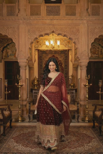 Velvet Lehenga Set by Saroj Jain, designed for women who embrace heritage with confidence and grace. Crafted in rich maroon velvet, this ensemble captures the grandeur of royal Indian artistry while maintaining a refined, contemporary silhouette.