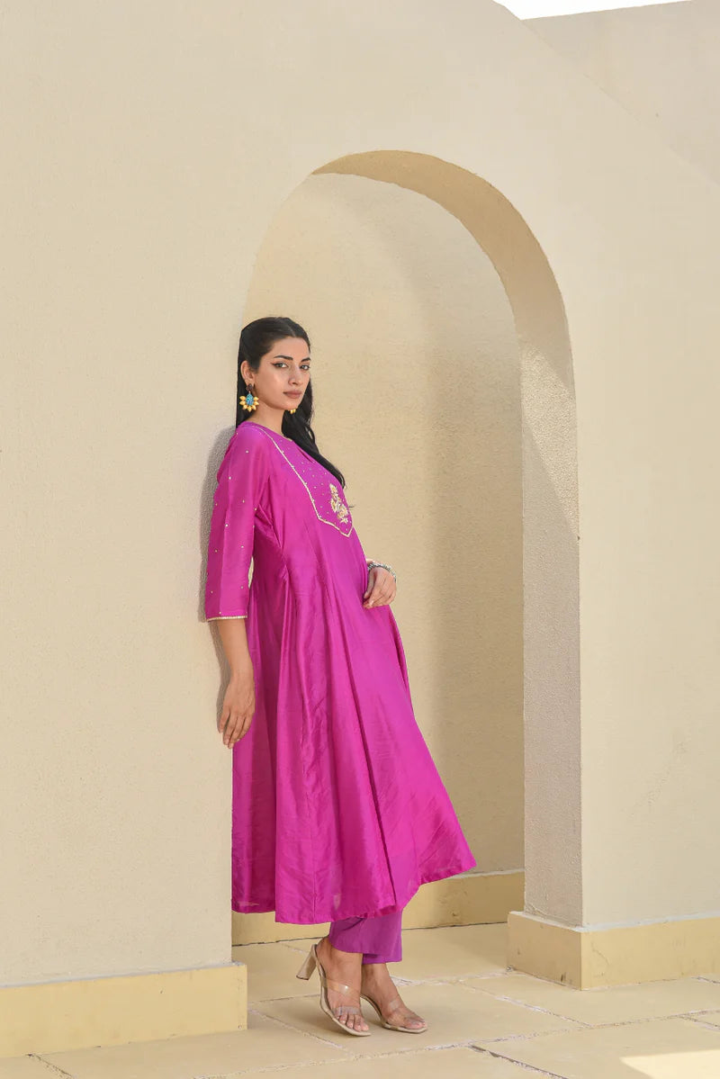 This purple Chanderi silk set includes an A-line kurta with a keyhole neckline, 3/4 sleeves, and a pull-up closure, paired with a comfortable cotton pant. Highlighted with intricate zardozi work, it's a perfect pick for elegant festive wear.